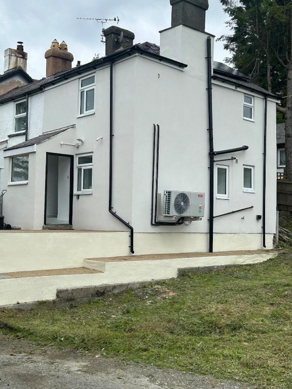 a white house with a fan on the side of it at Valley View in Llandegla