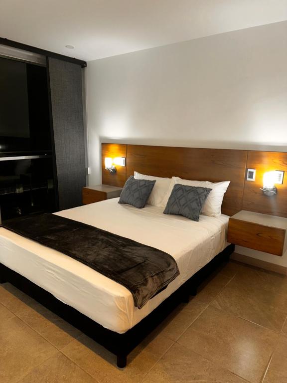 a bedroom with a large white bed with two lamps at Deluxe Armenia Apartment in Armenia