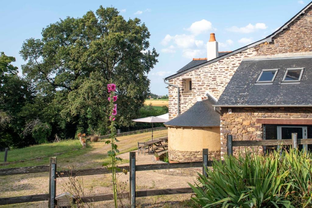 een stenen huis met een hek en een tuin bij La Hulotte in Saint-Malon-sur-Mel
