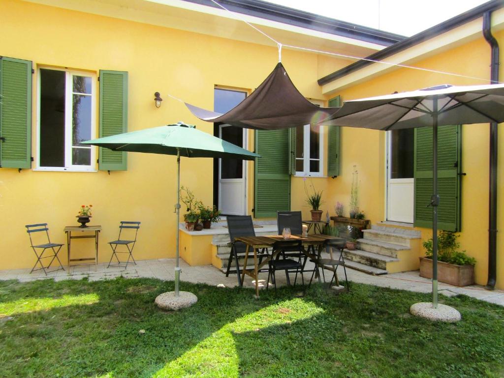 a patio with two umbrellas and a table and chairs at Il Tulipano in Camaiore