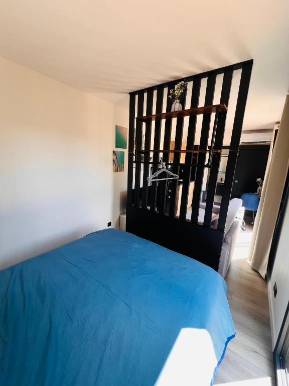 1 dormitorio con cama azul y cabecero negro en La Mer au cœur de la Nature, en Rosselange