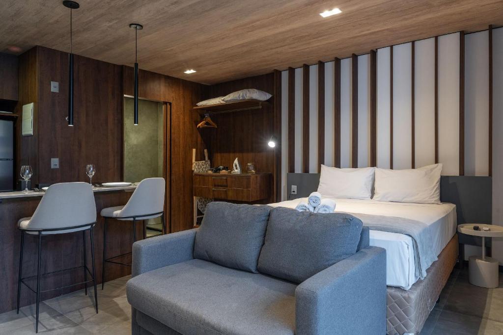 een slaapkamer met een bed en een stoel en een keuken bij Edifício New Time Apto 1406-Mandi Hospitalidade in Maceió