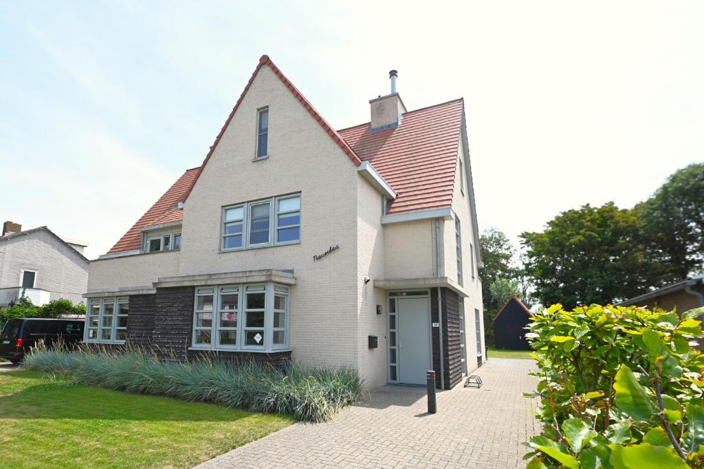 a white house with a red roof at Villa Mer - Large luxury family holiday home Villa Nausikaä in Cadzand