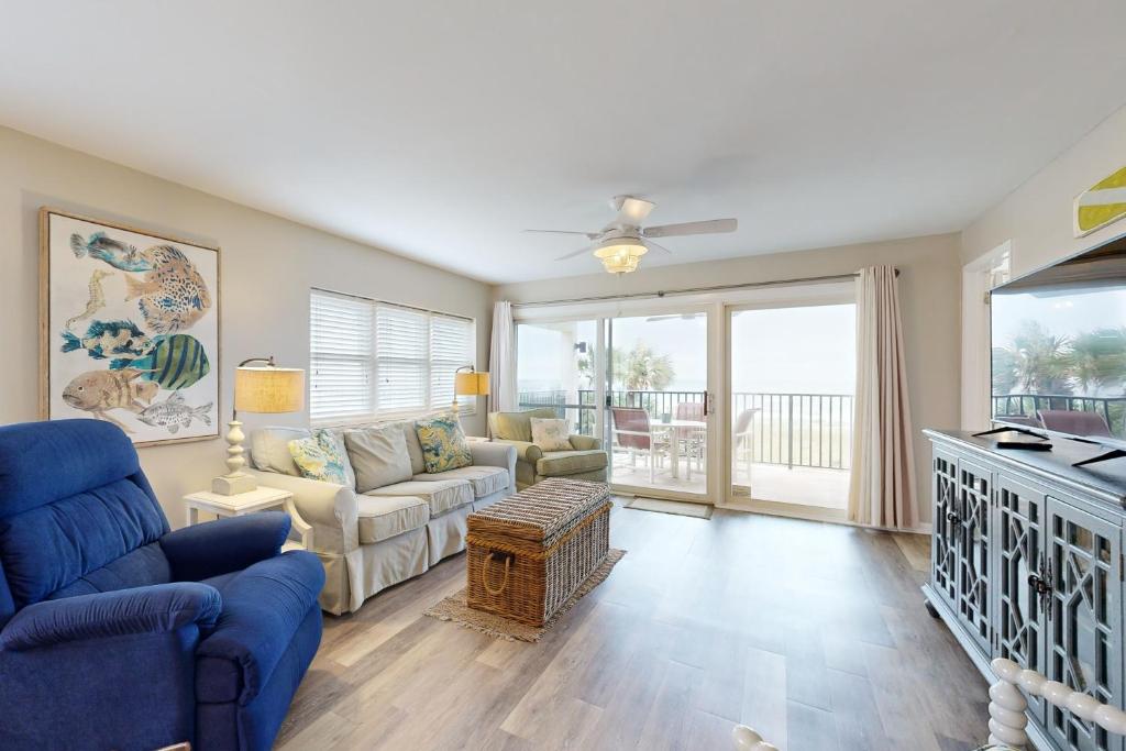 Oceanfront corner condo with sunrise-view balcony, pool & 1-minute walk to beach في فرناندينا بيتش: غرفة معيشة مع أريكة وتلفزيون