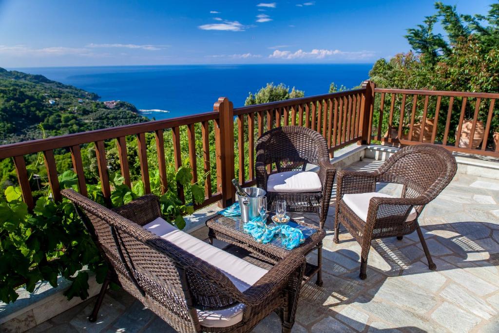 a patio with chairs and a table with a view of the ocean at Lions Nine in Mouresi