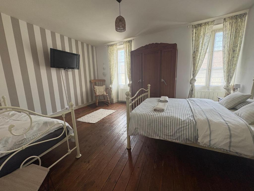 ein Schlafzimmer mit einem Bett und einem Fernseher an der Wand in der Unterkunft Town Centre with garden & free parking Le Dorat in Le Dorat