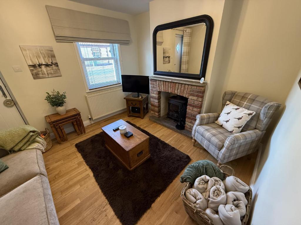 a living room with a couch and a fireplace at Autumn Cottage in Filey