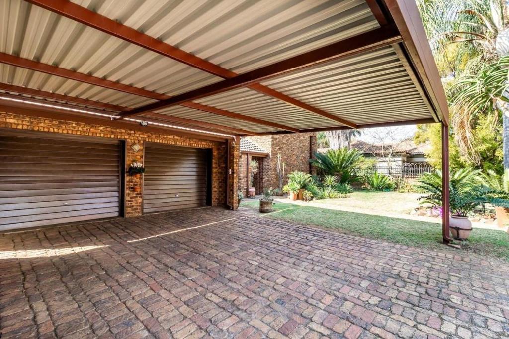 a garage with awning over a brick driveway at VillaDelux in Pretoria