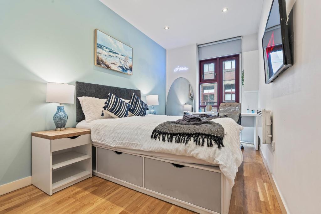 Schlafzimmer mit einem Bett, einem Schreibtisch und einem TV in der Unterkunft Central Leeds Flat - In City Centre - Modern Décor - Sleeps 8 in Central Station