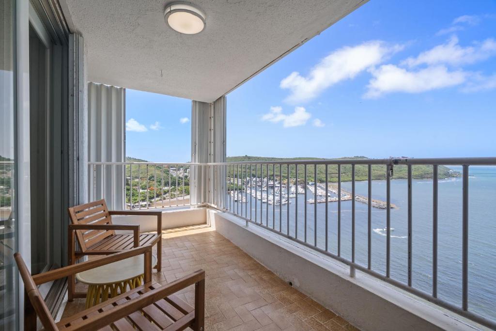 a balcony with chairs and a view of the ocean at Waterfront Apartment Balcony Marina Shared Pool in Fajardo