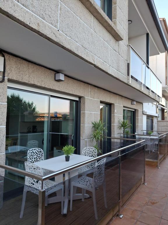 ein Balkon mit Tisch und Stühlen an einem Gebäude in der Unterkunft Combarro Mar in Combarro