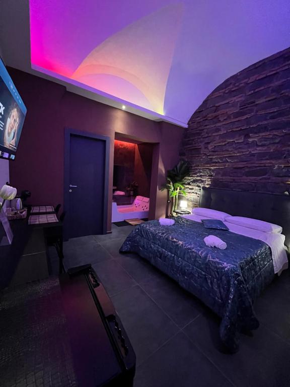 Un dormitorio con una cama y una pared de ladrillo. en Il Casale del 900, en Catania