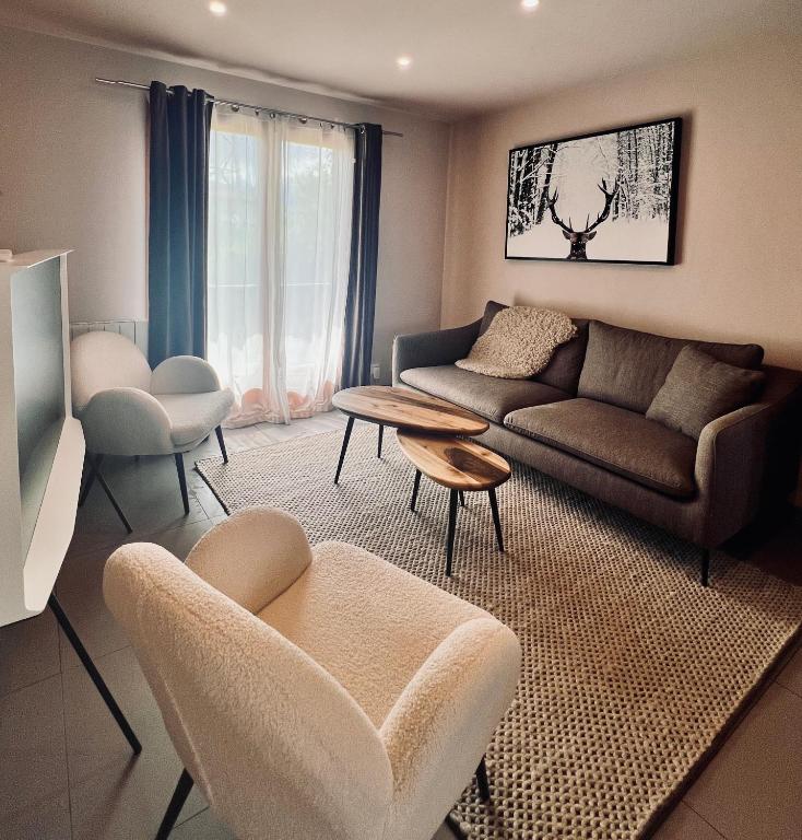 a living room with a couch and a table at les colibris in Passy