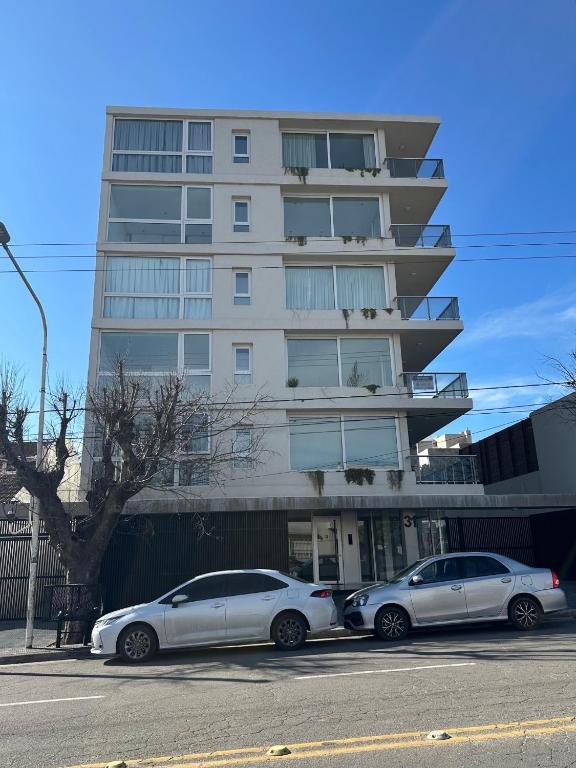 two cars parked in front of a building at Raíz Urbana in Tandil