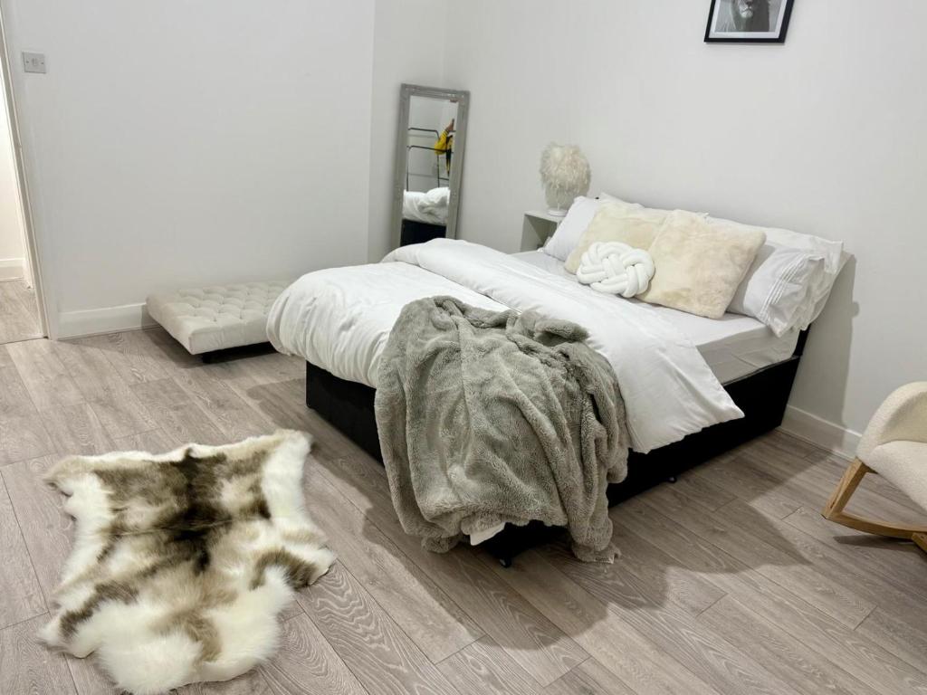 a bedroom with a bed with a blanket and a rug at The Edgbaston Retreat in Birmingham