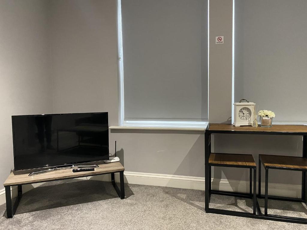 a flat screen tv sitting on top of a table at Chic Maidstone getaway in Maidstone