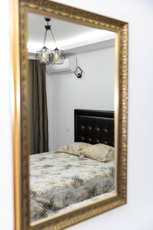a mirror reflecting a bed in a bedroom at Apartments Ceka in Ulcinj