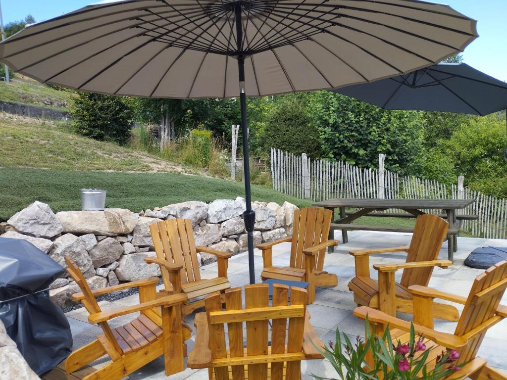 un groupe de chaises et un parasol sur une terrasse dans l'établissement Appartement spacieux à Le Tholy, 6 pers, Vosges - FR-1-589-784, à Le Tholy