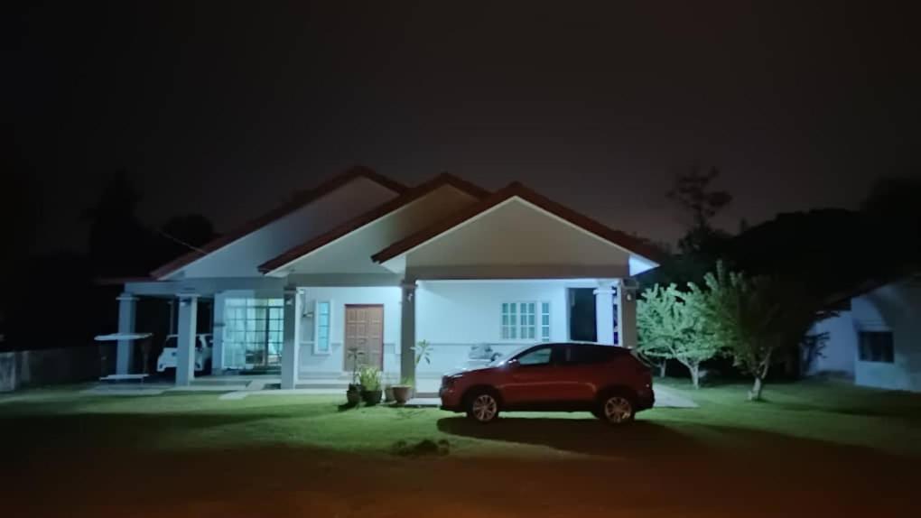 a car parked in front of a house at night at Merbok Little Bungalow in Kampong Merbok