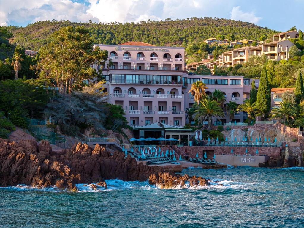 a building on the shore of a body of water at Tiara Miramar Beach Resort in Théoule-sur-Mer