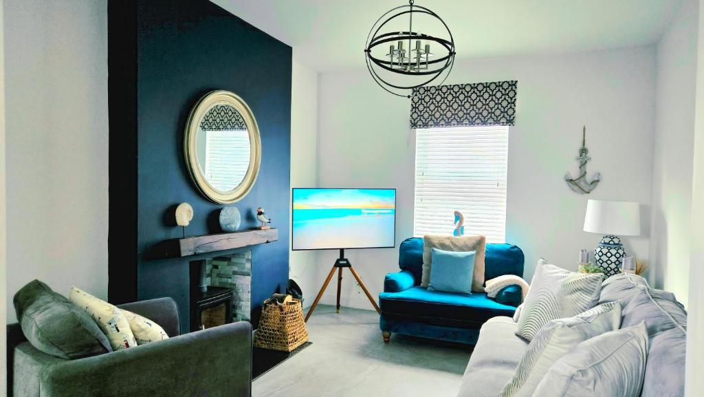 a living room with a couch and a chair at Sandy Beaches Portrush - Steps from Beach & Dining in Portrush