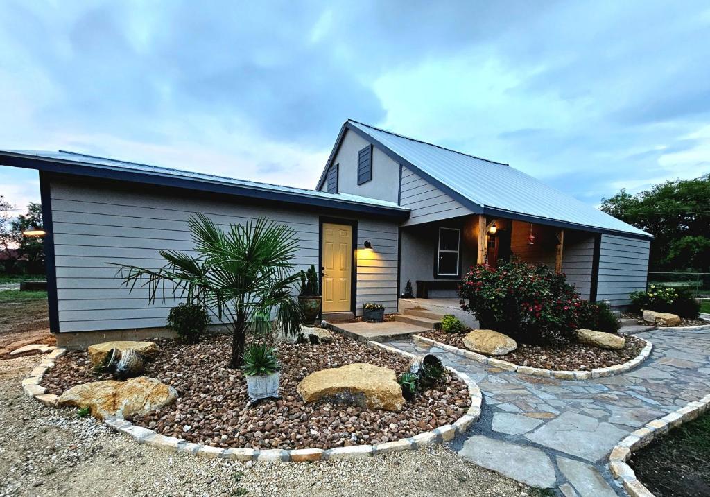 a house with a garden in front of it at Historic Farmhouse - Tranquil Country Nature Escape in Hondo