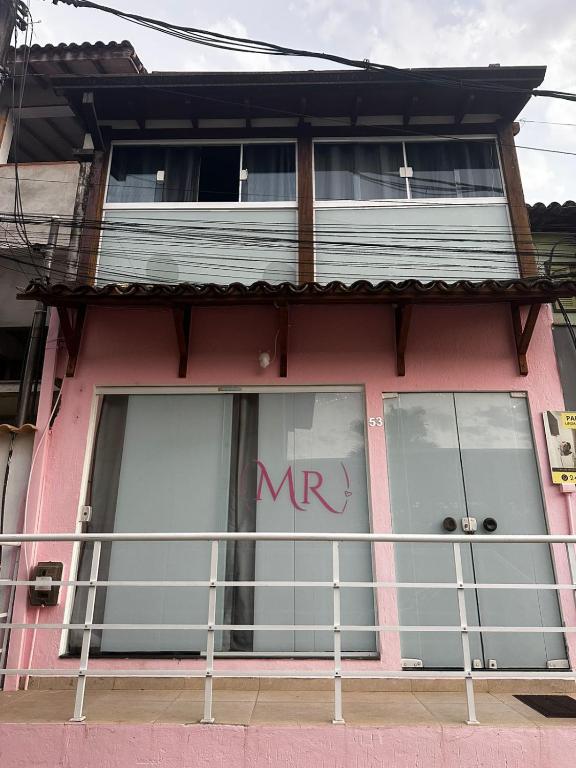 a pink building with a m sign on the window at Hospedagem Marceli in Paraty