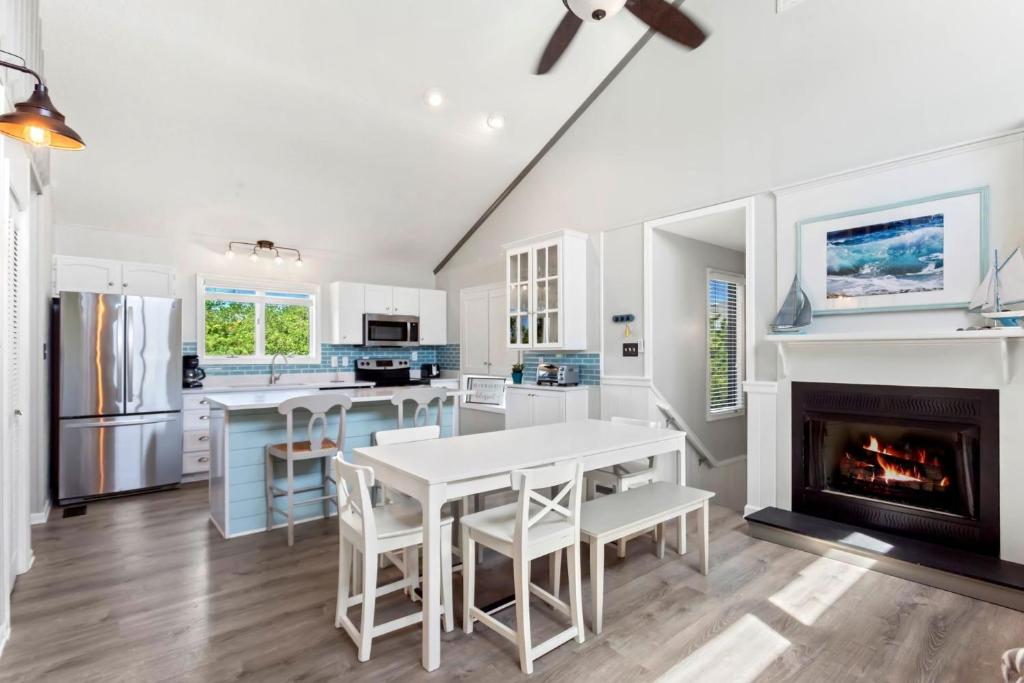 a kitchen with white cabinets and a fireplace at 1689 - Maison de la Mer in Poplar Branch
