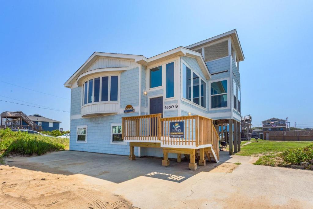 une maison avec une terrasse couverte et un banc devant elle dans l'établissement 4080 - Betcha Like It, à Kitty Hawk