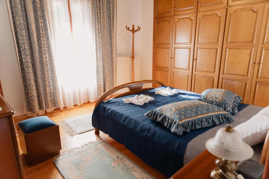 a bedroom with a blue bed with towels on it at Aria Archontiko Pelion in Katochori