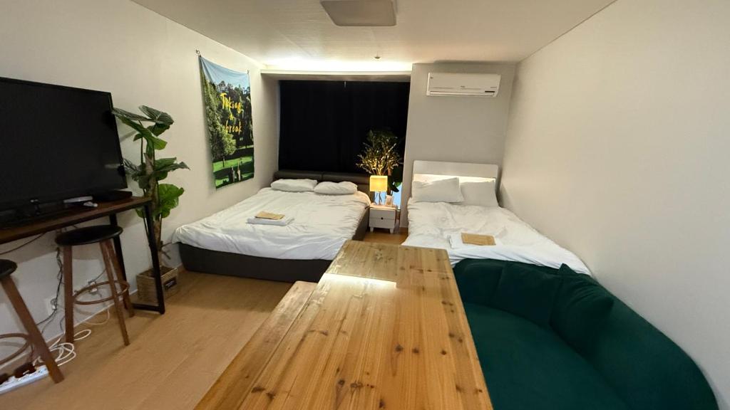 a room with two beds and a television in it at Kozy House in Gangnam in Seoul