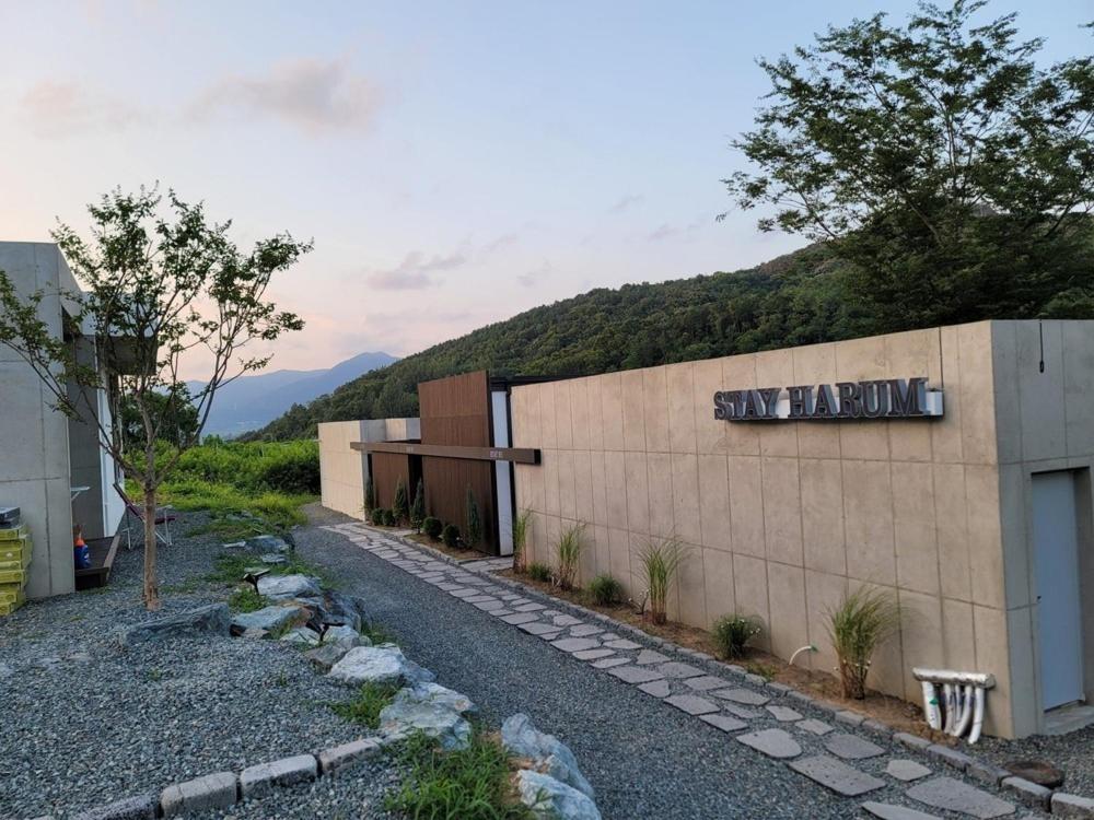een gebouw met een muur met een berg op de achtergrond bij Stay Harum Cheongdo in Hŭksŏk