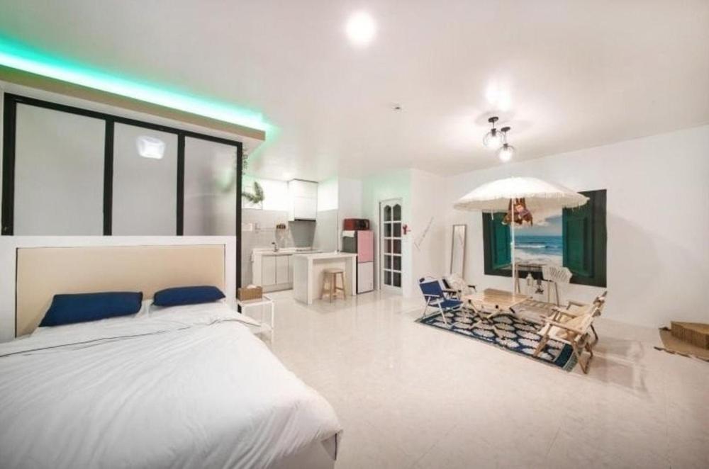 a bedroom with a bed and chairs in it at Jeryeong Forest Pension in Gapyeong