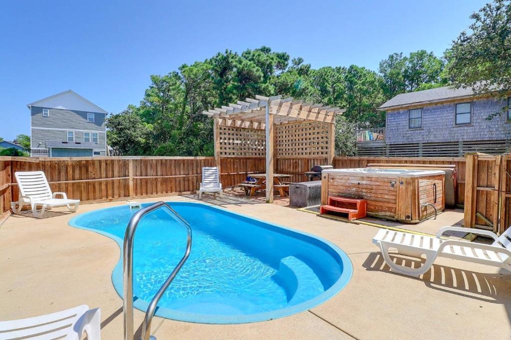 un patio trasero con piscina y una valla de madera en 6045 - Summer Fun II, en Nags Head