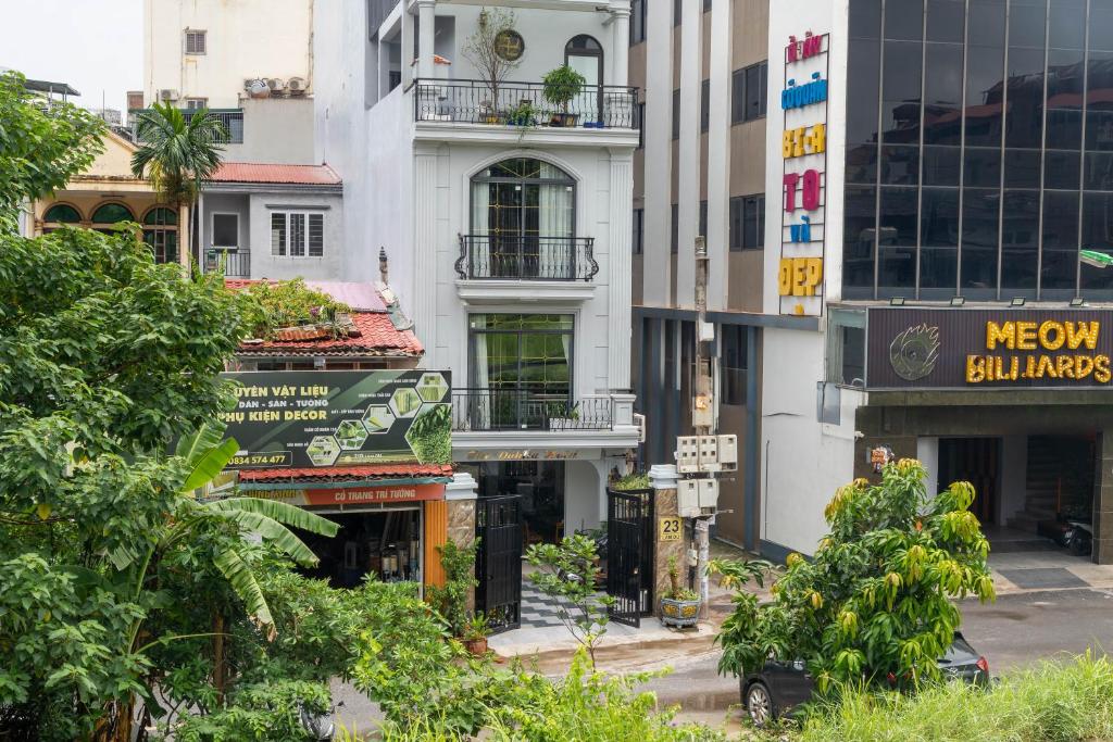 a city street with tall buildings and trees at The Dahlia Hotel & Apartments in Hanoi