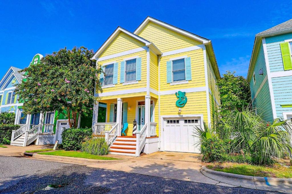 a yellow house with a white garage at BB47 - A Wave From It All in Kill Devil Hills