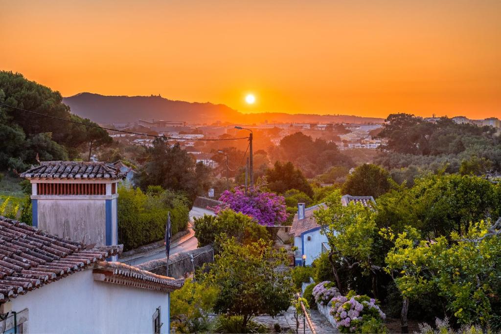 a sunset over a city with houses and trees at Silent Place - Sintra in Paiõis
