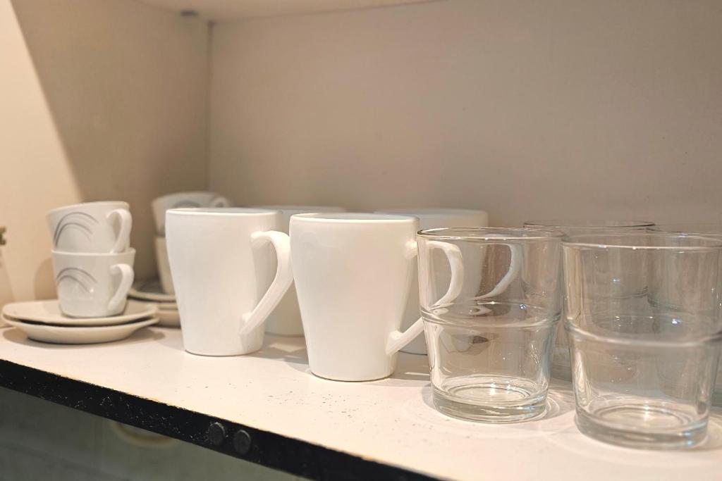 a group of glasses and vases sitting on a shelf at Departamento centrico in Rosario