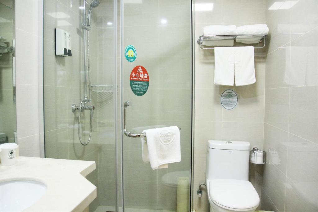 a bathroom with a shower and a toilet and a sink at GreenTree Inn Ji‘nan Shanda Road Business Hotel in Jinan