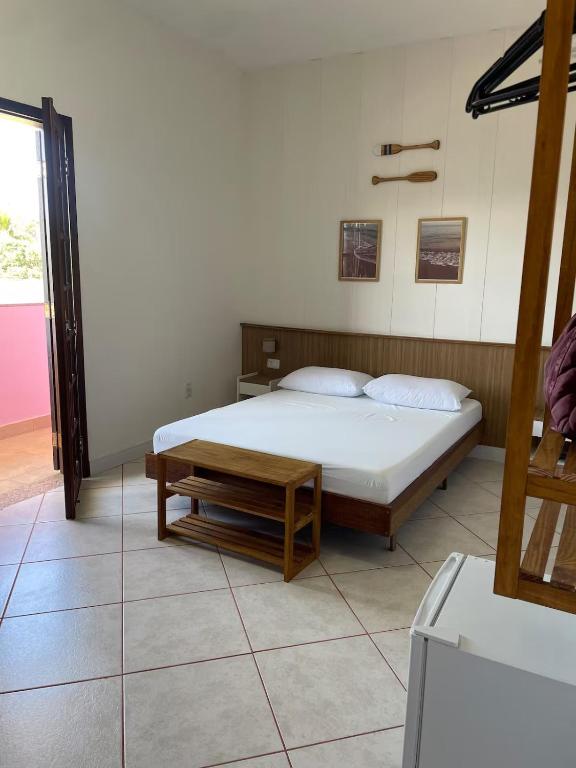 a bedroom with a bed and a bench in it at Apartamento beira-mar in Ilha Comprida