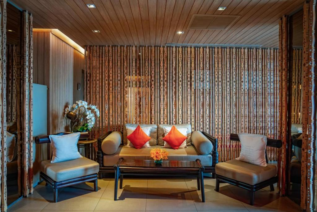 A hotel lounge with a sofa, armchairs and decorative wood partitions.