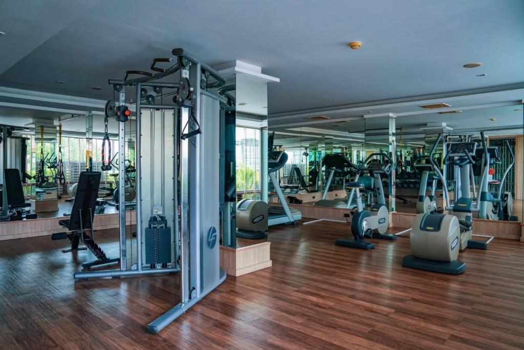 A mirrored hotel gym with cardio equipment and a cable machine.