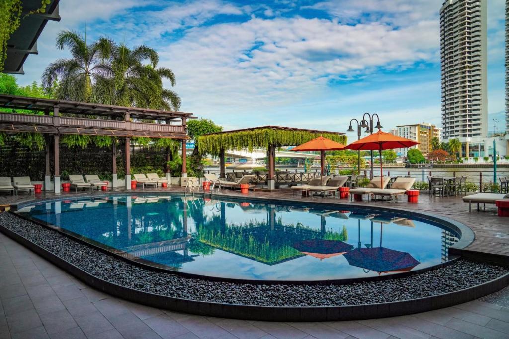 A rooftop-style pool terrace with riverfront city surroundings.