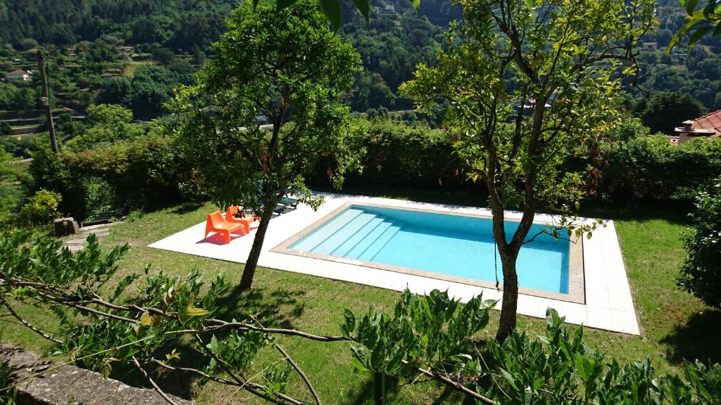 a swimming pool in the middle of a yard with trees at Quinta da Bouça - Agroturismo in Paços de Gaiolo