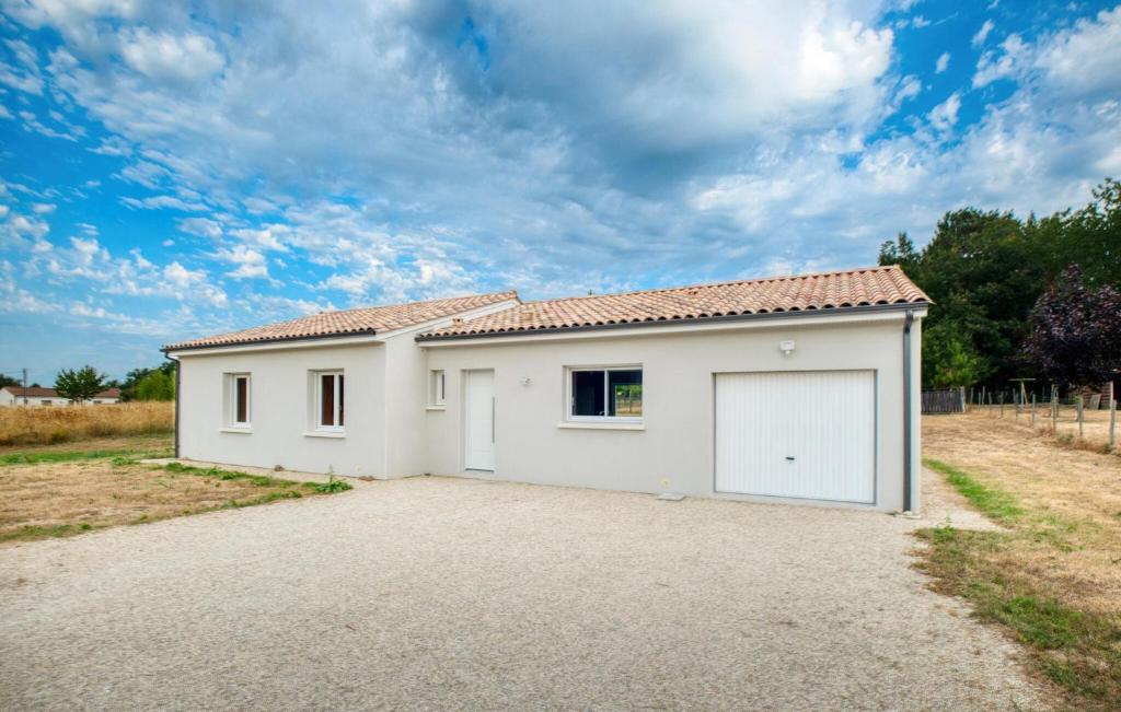 ein weißes Haus mit einer Garage auf einer Einfahrt in der Unterkunft Charmante Maison À La Campagne in Laveyssière