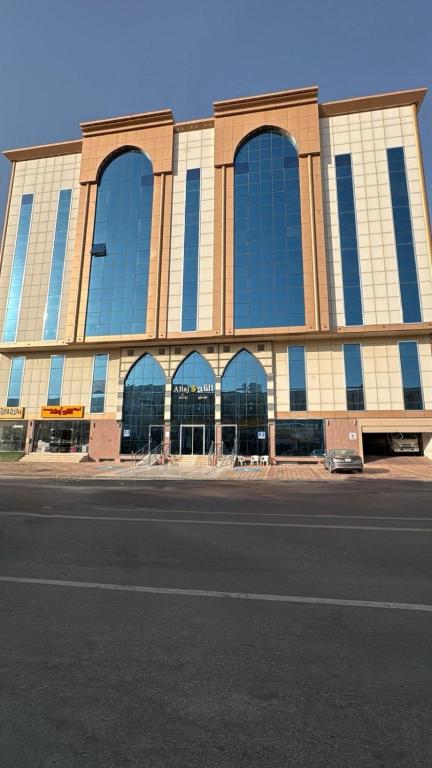a large building with windows on the side of a street at التاج ثلاثة الفندقية in An Nikāshah