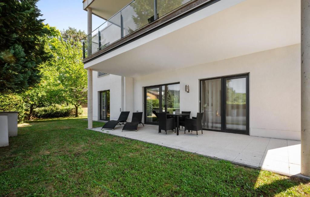 a patio with a table and chairs on a lawn at Ferienwohnung 90M² in Pörtschach am Wörthersee