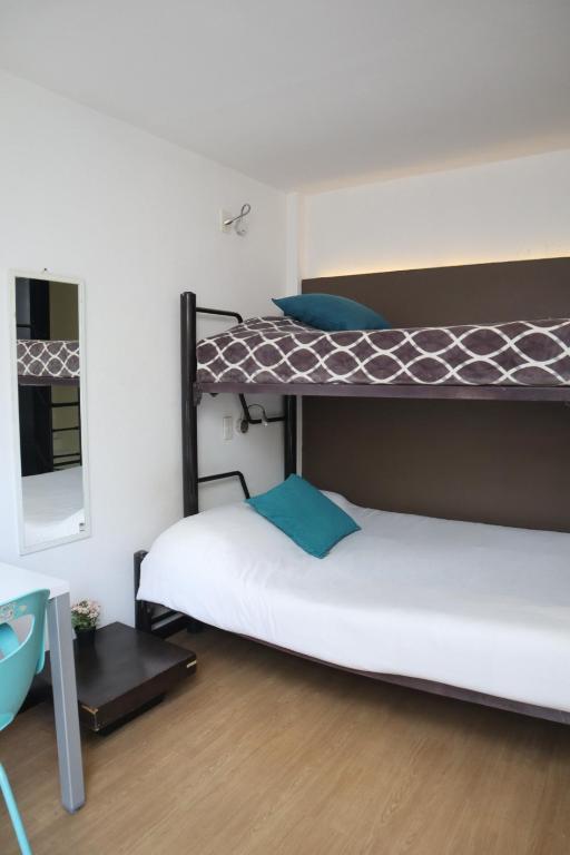 two bunk beds in a room with a mirror at Hermosa Habitación con balcon cama mat y litera Polanco in Mexico City
