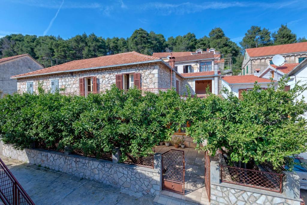 Ein Haus mit einem Haufen Bäume an der Wand in der Unterkunft Holiday Home Leonida in Jelsa