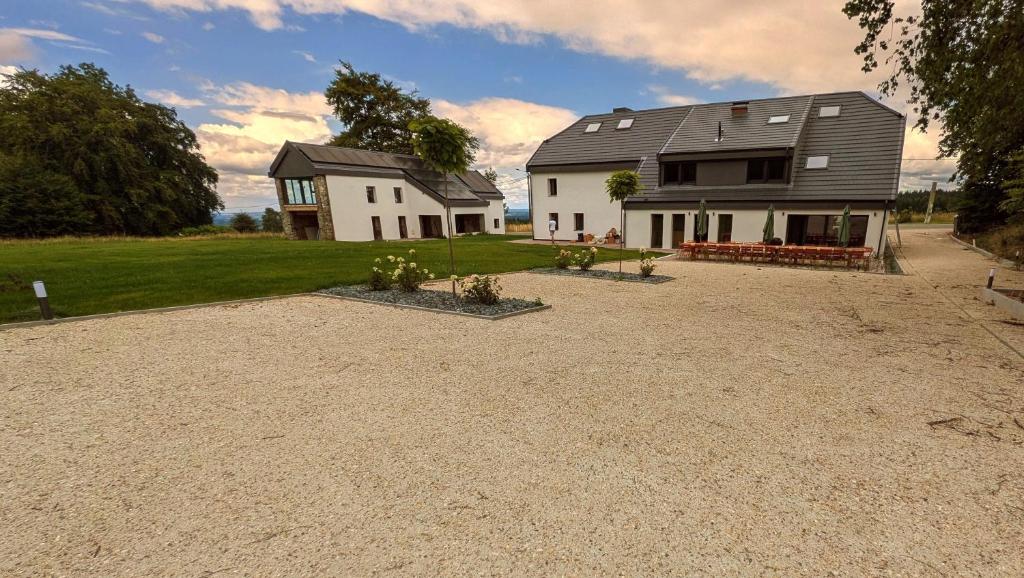a house with a gravel driveway in front of it at La Source du Lodji by WelcHome in Spa